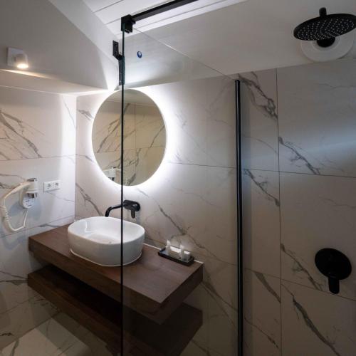 a bathroom with a sink and a glass shower at Curacao Avila Beach Hotel in Willemstad
