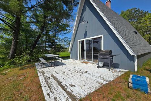 a blue building with a picnic table and a grill at A-Frame on East Bay in Williamsburg