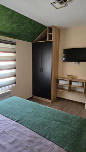a bedroom with a bed and a flat screen tv at Apartman Tanja in Nova Varoš