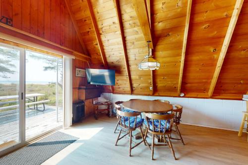 a dining room with a table and chairs and a tv at A-Frame on East Bay in Williamsburg