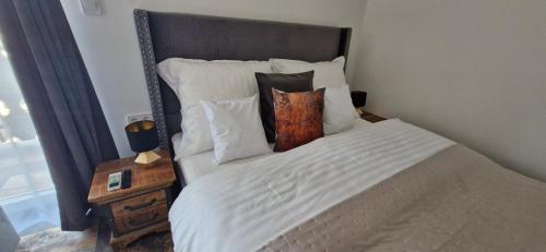 a bedroom with a bed with white sheets and pillows at Kapitány MP Art Luxury Apartman in Balatonboglár