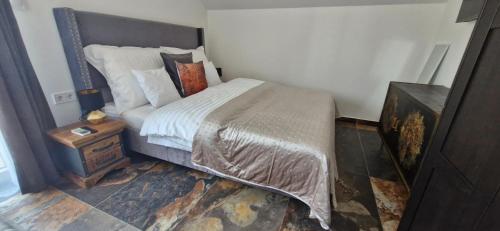 a small bedroom with a bed with a nightstand and a bed sidx sidx sidx at Kapitány MP Art Luxury Apartman in Balatonboglár