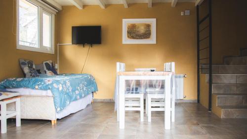 une chambre avec un lit, une table et des chaises dans l'établissement Apart BANDURRIAS I - a 200ms del Lago Lacar, à San Martín de los Andes