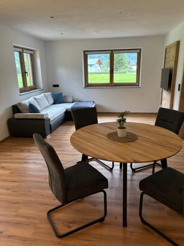 a living room with a table and chairs and a couch at Haischberger Apartments in Obertraun