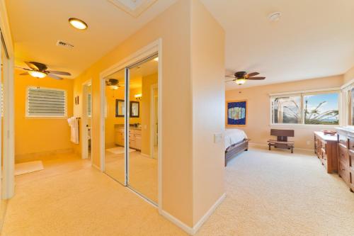 a large bathroom with yellow walls and a bedroom at Kona Vistas by SkyRun Kona Coast in Kailua-Kona