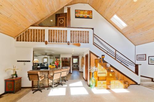 a kitchen and living room with a staircase and a house at Lua Hoana Place by SkyRun Kona Coast in Waikoloa Village
