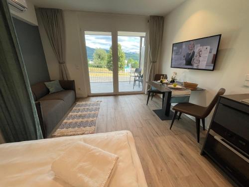 a living room with a couch a table and a tv at Stunning Wörthersee Holiday Home 16 in Sekull