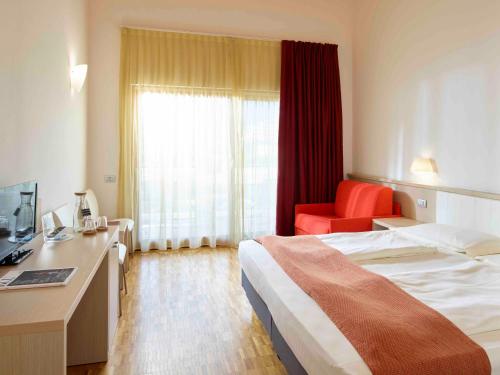 a hotel room with a bed and a desk at Garda Sporting Club Hotel in Riva del Garda