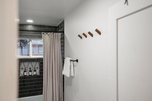 a bathroom with a shower with a shower curtain at Fun-Filled Backyard Firepit Grill Games Good Vibes in Houston