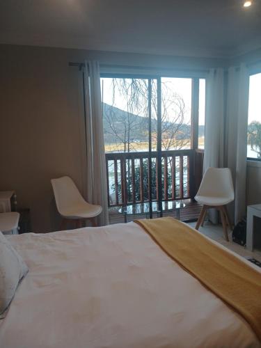 a bedroom with a large bed and a balcony at Cozy Kosmos in Hartbeespoort