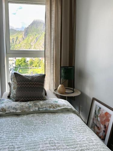 a bedroom with a bed and a large window at Mountain and Sea View Svolvær in Svolvær