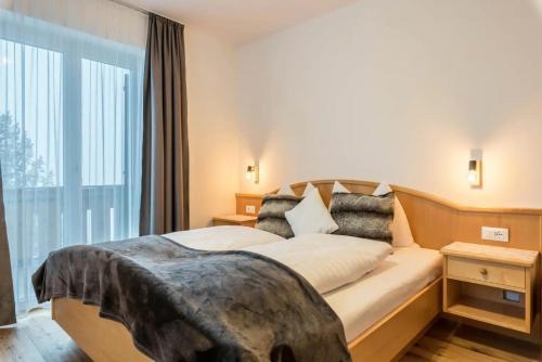 una camera d'albergo con un letto e una grande finestra di Sonnleitn a Laion
