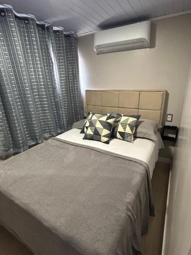 a bedroom with a large bed with pillows at Linda e Ampla Casa Inteira Próxima ao Centro de Criciúma in Criciúma