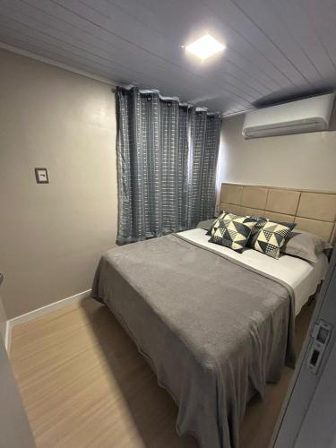 a bedroom with a large bed with pillows on it at Linda e Ampla Casa Inteira Próxima ao Centro de Criciúma in Criciúma