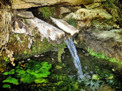 a stream of water coming out of a stone wall at Mountain Getaway in Laroya in Laroya
