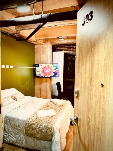 a bedroom with a bed and a flat screen tv at Beautiful loft with elevator for nomad envigado in Envigado