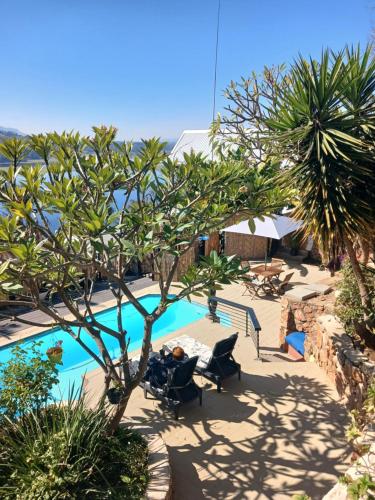 a swimming pool with a table and chairs and trees at Cozy Kosmos in Hartbeespoort
