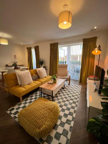 a living room with a yellow couch and a table at Issara Apartments 35 - Great Location & Private Parking in Portsmouth