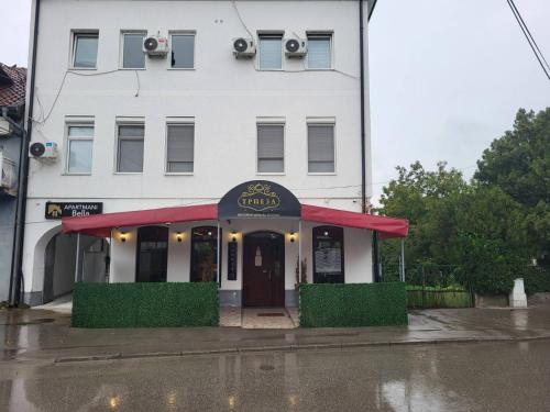 a restaurant with a red awning in front of a building at Trpeza Prenociste in Požarevac