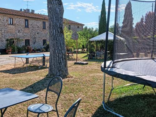 a ping pong table and chairs next to a tree at Agriturismo I Due Mondi in Montone