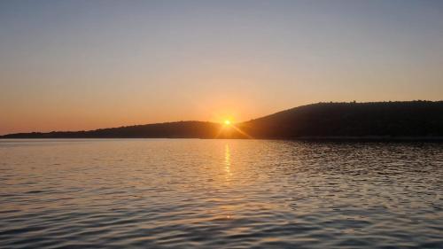 a sunset over a large body of water at Sunset Apartment in Sevid