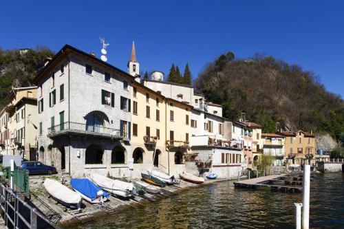 a building with boats docked next to a river at Balcone Di Alex & Thomas - Happy Rentals in Val Rezzo