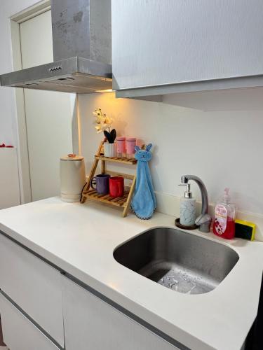 サンフェルナンドにあるAzure North Most Affordable Studio Staycation Suiteのキッチン(シンク、白いカウンタートップ付)