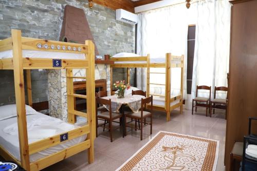 a room with bunk beds and a table and chairs at Univers Hostel in Berat