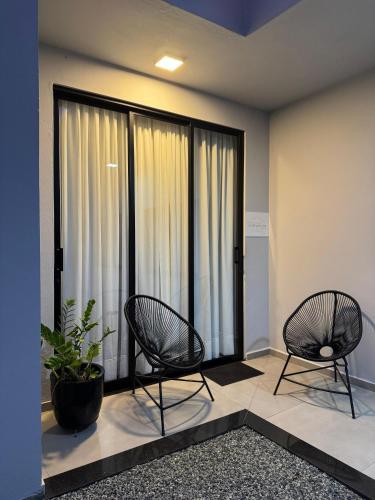 two chairs in a room with large windows at Espaço para Hóspedes LieblingsEcke in Pomerode