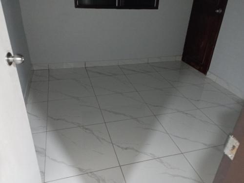 a room with a white tiled floor and a door at Hopesy's in Port Vila