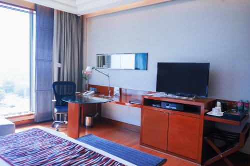 a hotel room with a television and a living room at Crowne Plaza Today Gurugram by IHG in Gurgaon