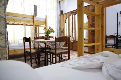 a bedroom with a bed and a table and chairs at Univers Hostel in Berat