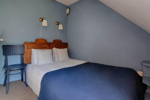 a small bedroom with a bed and a chair at Zuzmó Guesthouse, Jósvafő, Aggtelek National Park - Stylish 150 year old farmhouse for 10 guests in Jósvafő