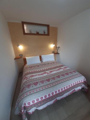 a bedroom with a large bed with a blanket on it at DolomitiCasa in Venas