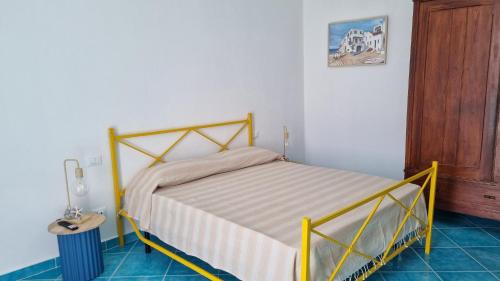 a bedroom with a bed in a room with a table at Brezza di Terra in Santa Marina Salina