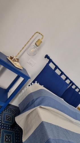 a bed with a blue bed frame and a lamp at Brezza di Terra in Santa Marina Salina