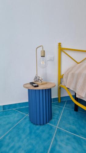 a room with a table with a lamp and a bed at Brezza di Terra in Santa Marina Salina