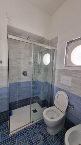 a bathroom with a toilet and a glass shower at Brezza di Terra in Santa Marina Salina