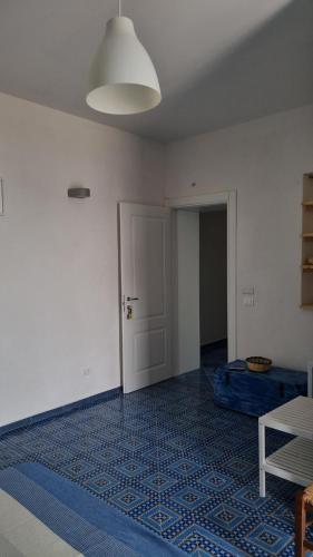 an empty room with a door and a blue carpet at Brezza di Terra in Santa Marina Salina