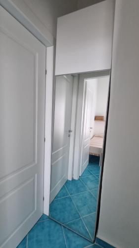 a mirror in a room with blue tile at Brezza di Terra in Santa Marina Salina