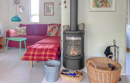 a living room with a fireplace and a purple couch at Lovely Home In Egå With Wifi in Egå