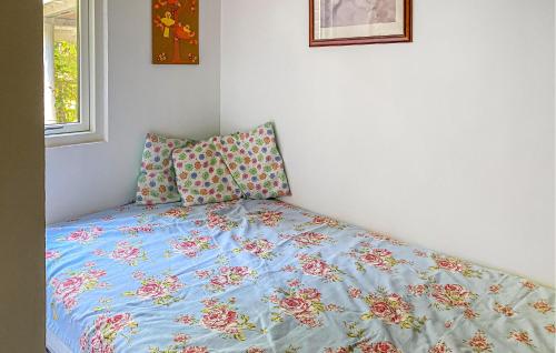 a bed with a blue comforter and two pillows at Lovely Home In Egå With Wifi in Egå