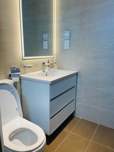 a bathroom with a white sink and a toilet at Spacious 3BR Luxury Apartment Trizen Colombo 2 Near City Centre in Colombo