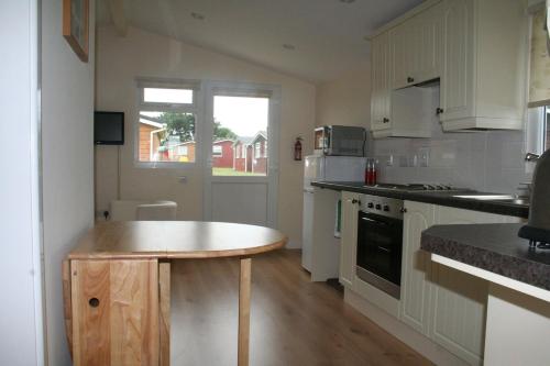 a kitchen with a table in the middle of it at Castaway Cabin in St Merryn