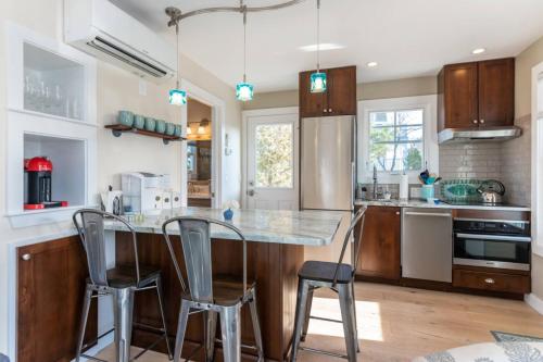 a kitchen with a island with chairs and a counter top at Plovers Nest in Newburyport