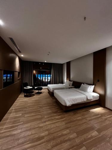 a large bedroom with two beds and a desk in it at فندق ايليقنت in Khamis Mushayt