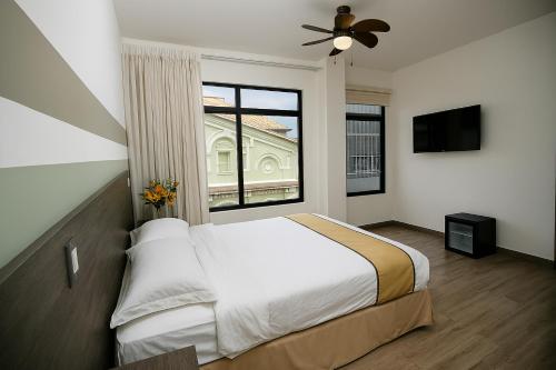 une chambre avec un lit et une grande fenêtre dans l'établissement Hotel Cultura Plaza, à San José
