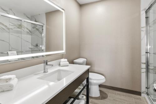 a bathroom with a sink and a toilet and a mirror at Motel 6 Tempe, AZ Elliot Road in Tempe