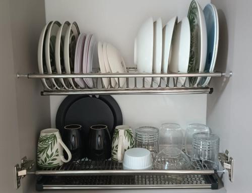 a shelf with plates and glasses on it at Casa Farallones a 20 minutos de Cali, Negocios, Familia, Casa tranquila, ideal para trabajos temporales o ejecutivos en la zona, descanso, privacidad, excelente señal wifi in Jamundí