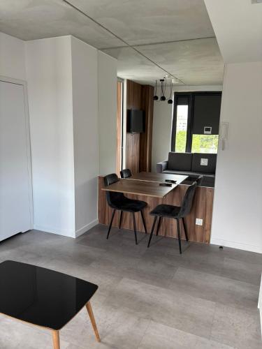 a dining room and living room with a table and chairs at Magnolia Loft Apartments in Wrocław